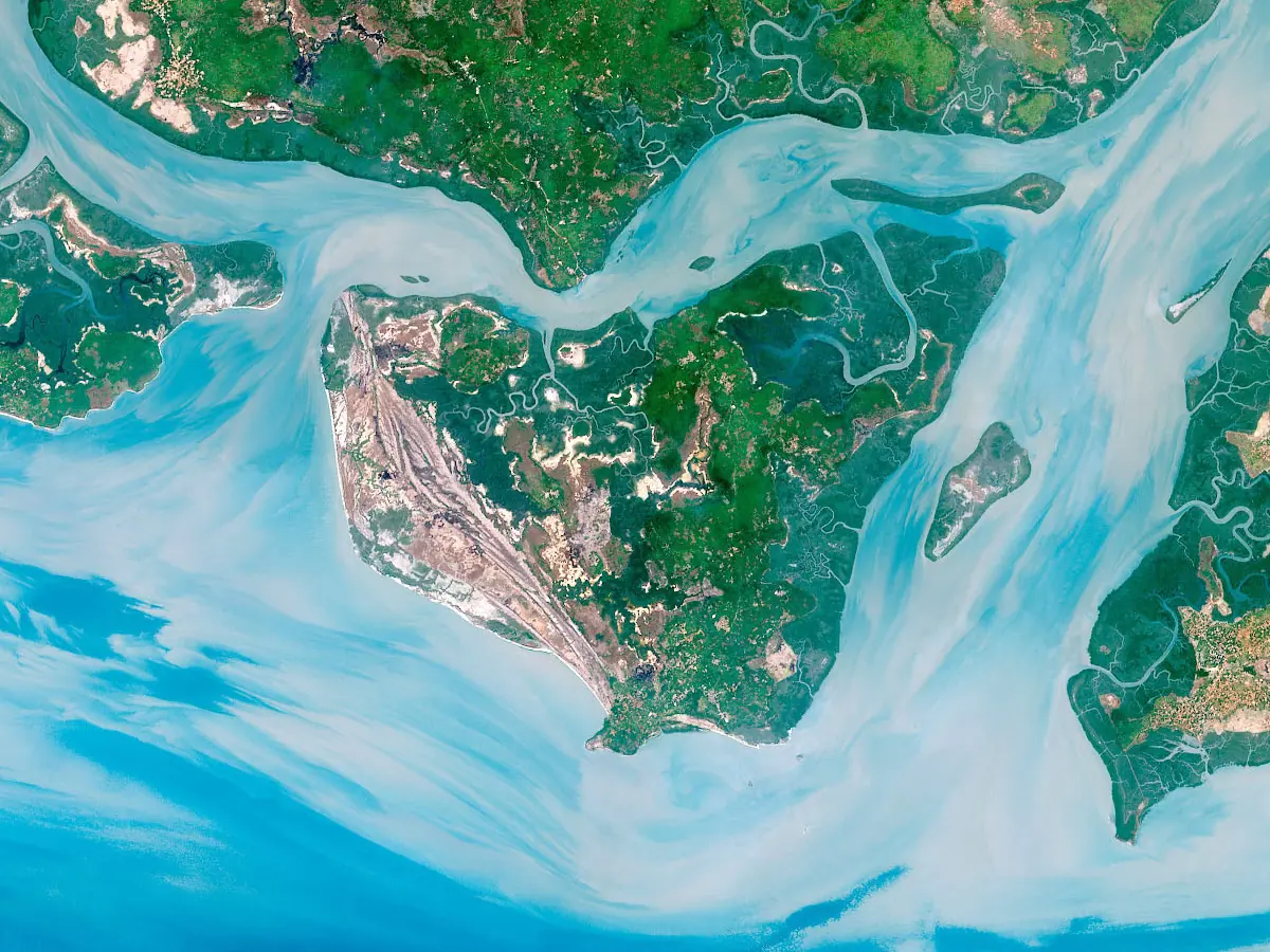 Pecixe island in Guinea-Bissau from above, green land framed by pale blue tidal channels
